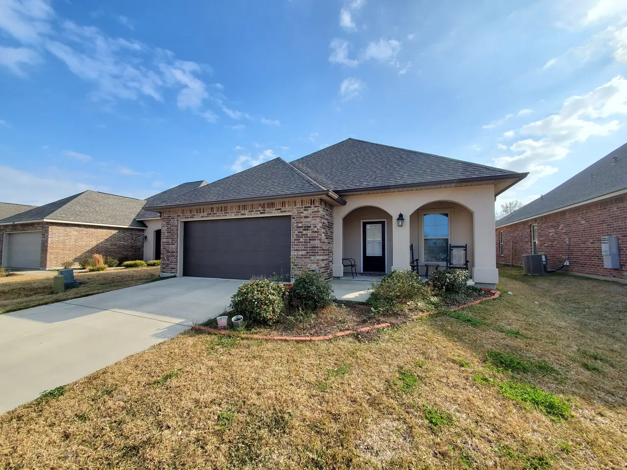 Brick and stucco home with a two-car garage and new white gutters