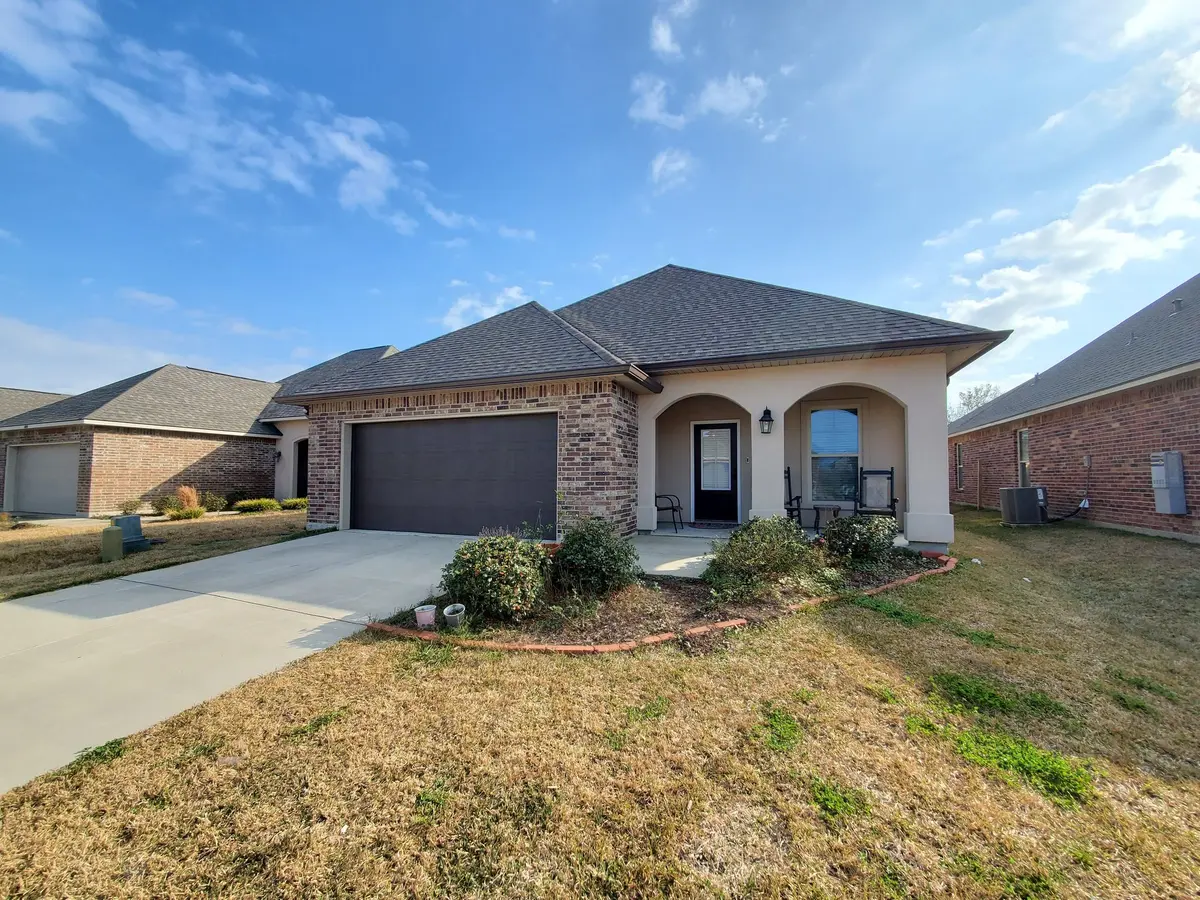 Brick and stucco home with a two-car garage and new white gutters