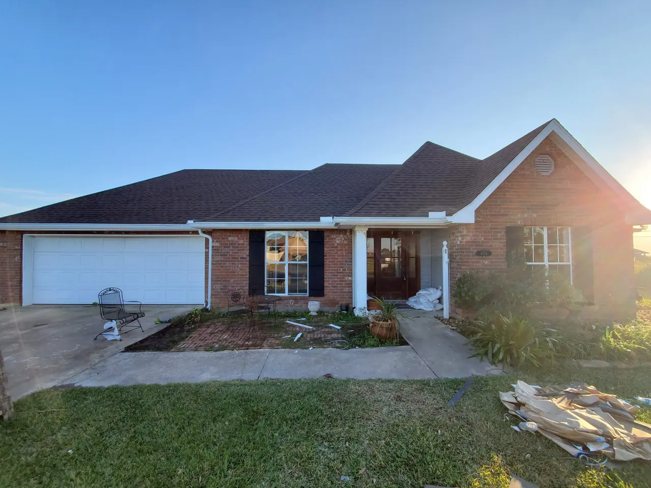 Brick and stucco home with a new white gutter over the garage