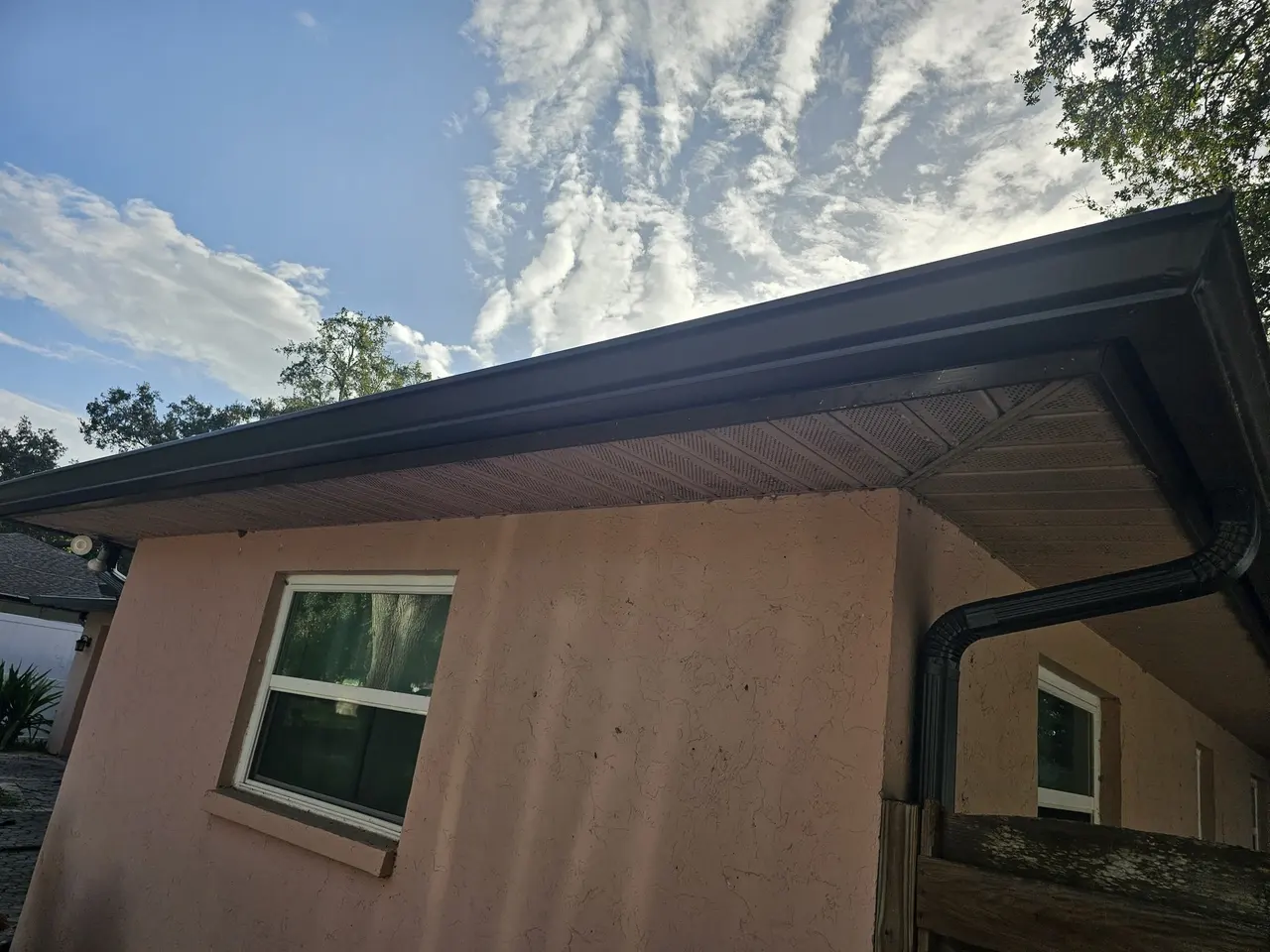 Bronze gutter along a low roofline against a bright sky