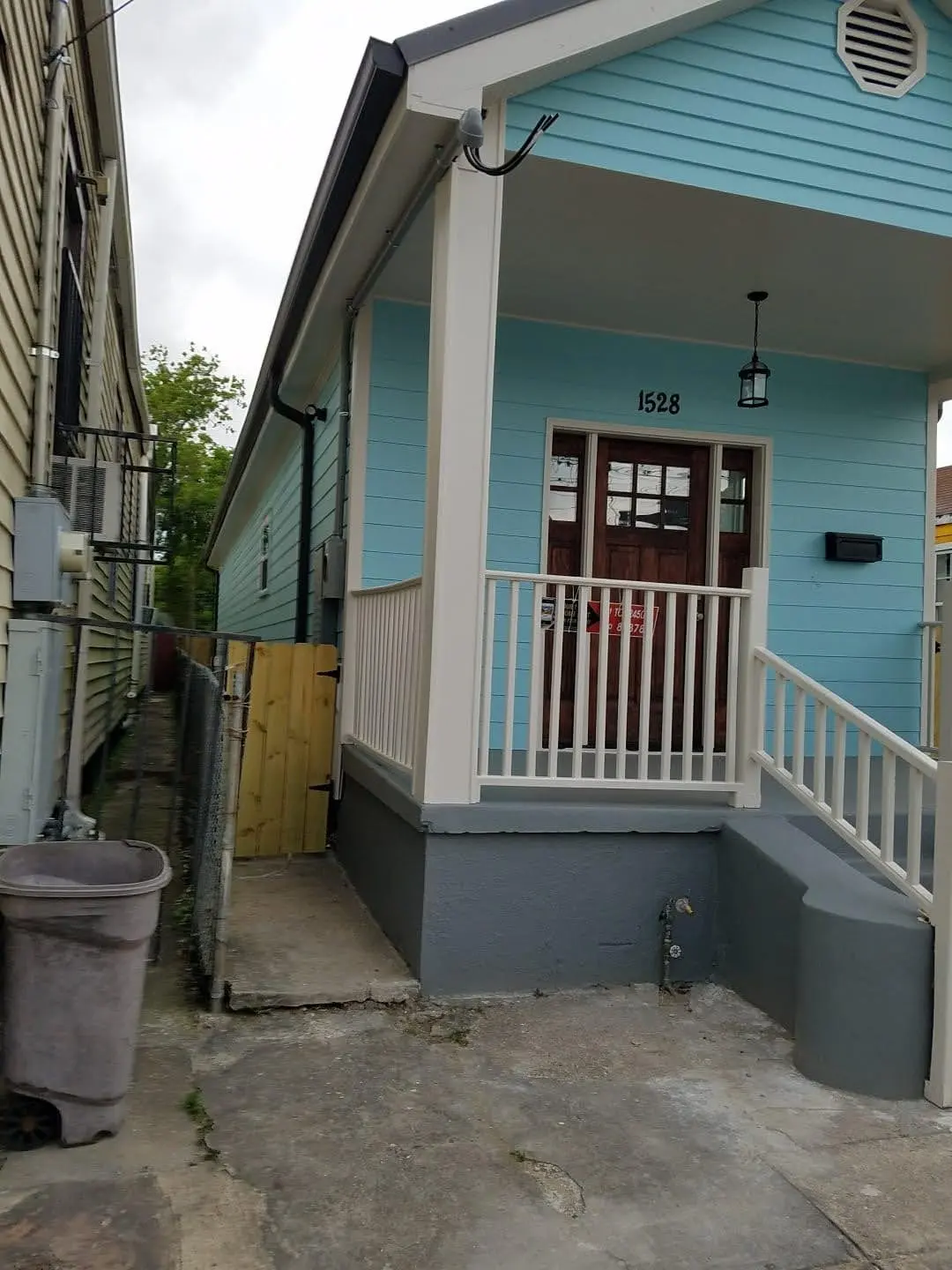 White gutter and downspout on the porch of a teal cottage