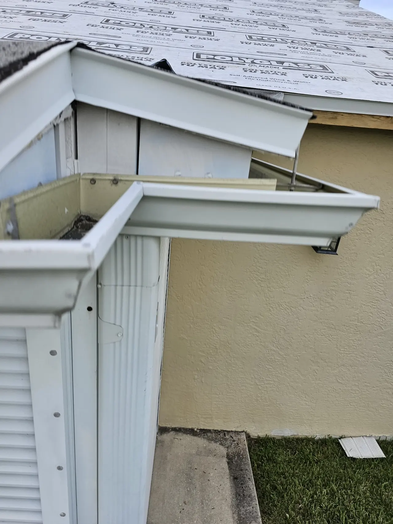 Close-up of a seamless gutter miter at a roof corner