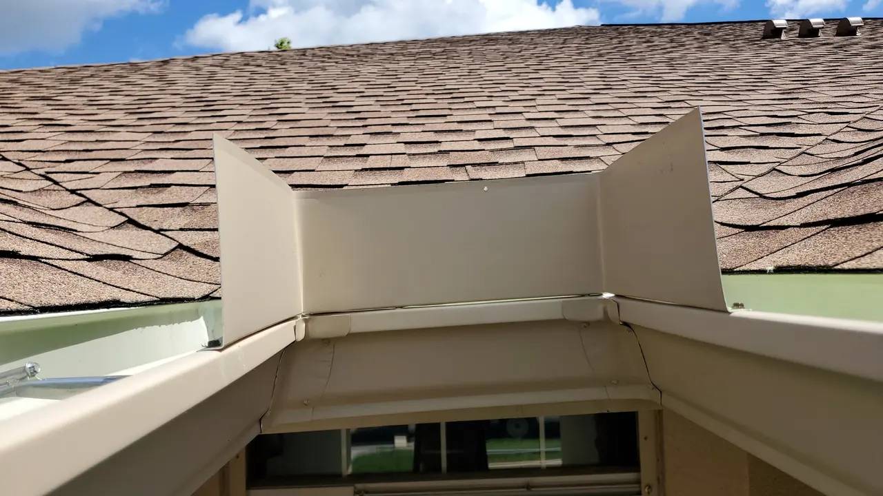 Gutter seen from the roof edge on a shingle roof