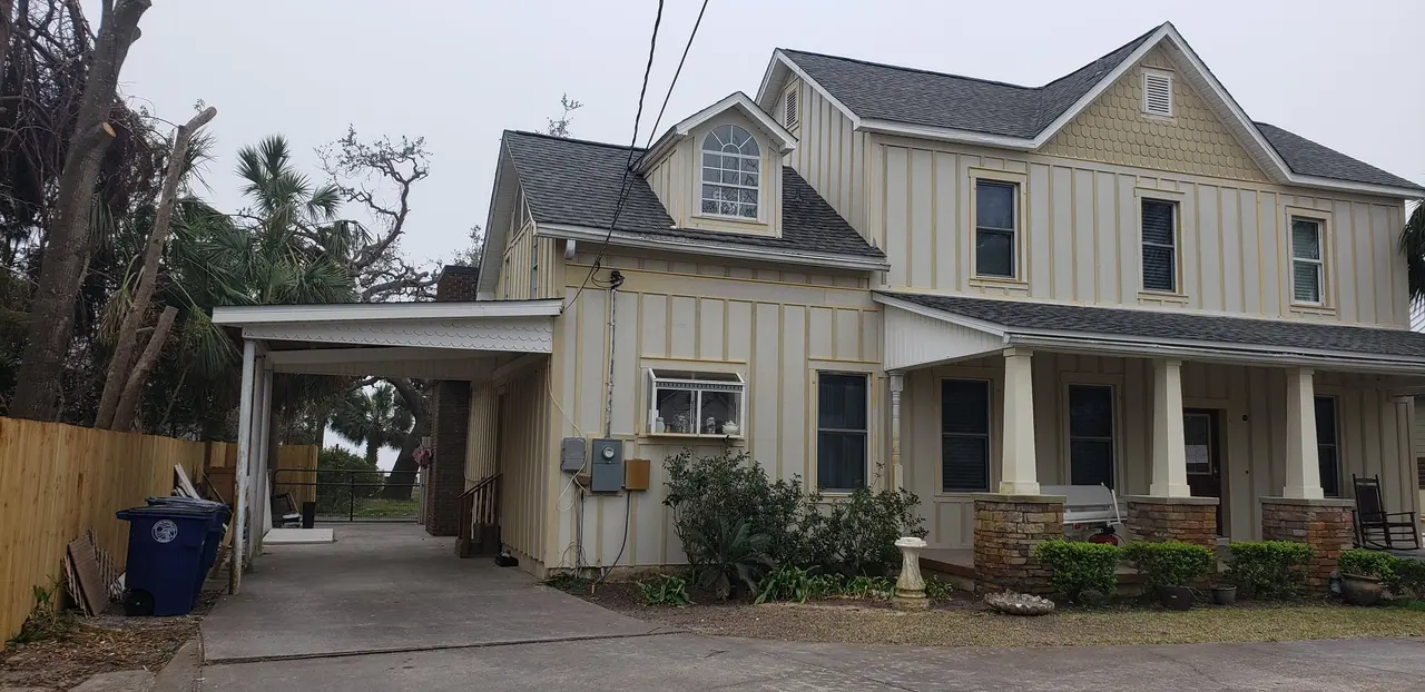Front of a two-story farmhouse with new white gutters