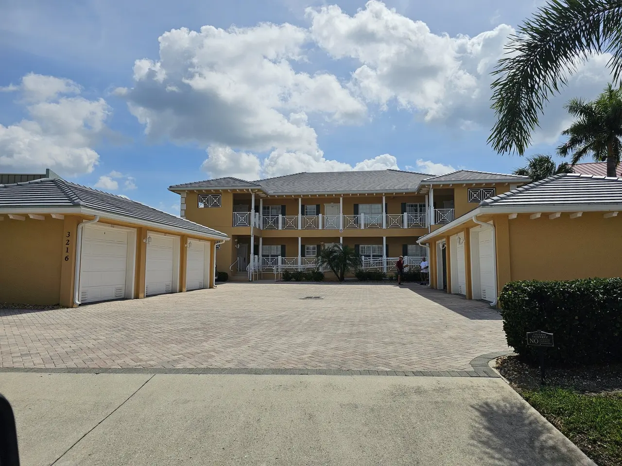Two-story building with tile roof and new seamless gutters over the garages