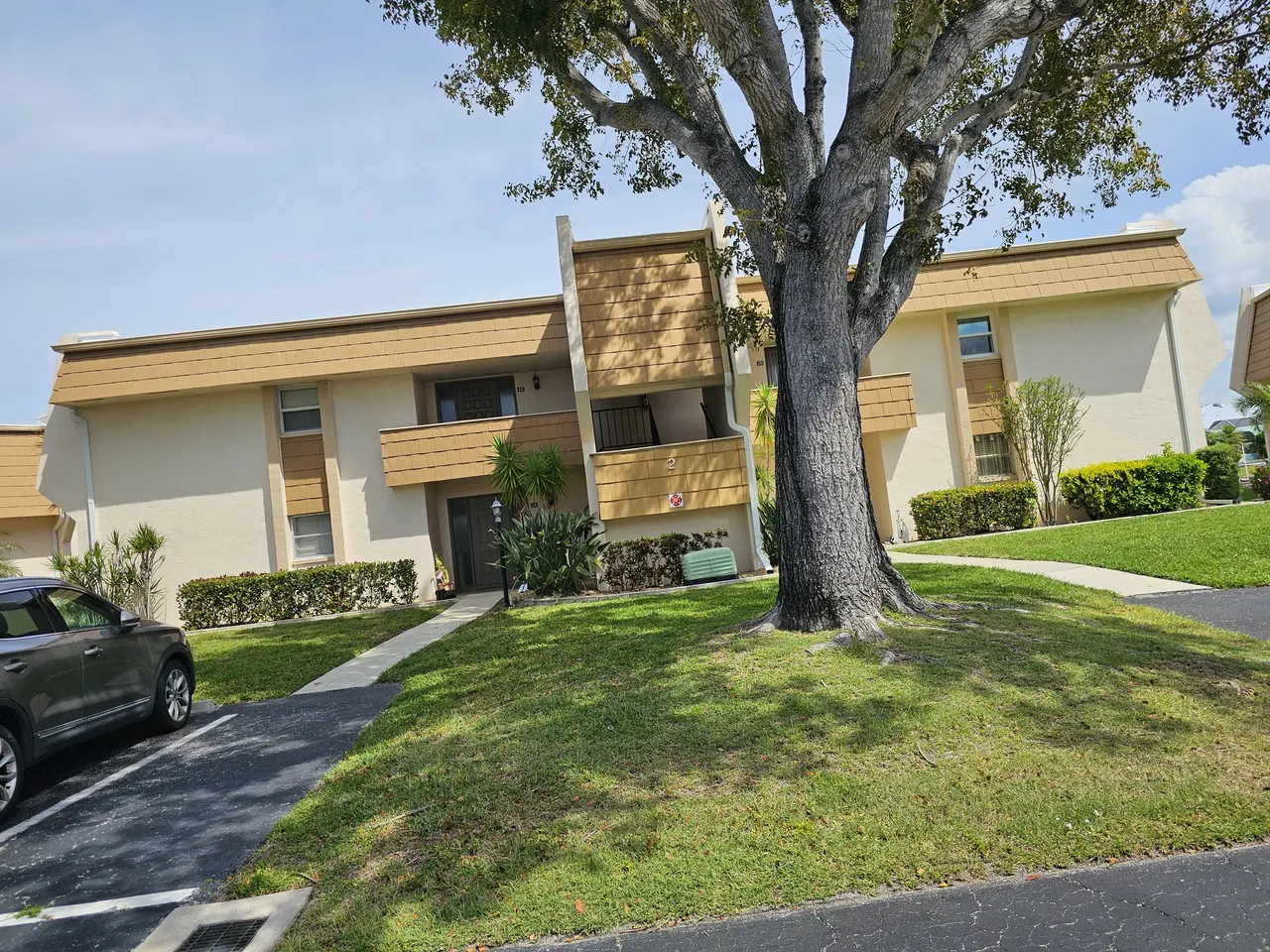 Two-story community building under a large oak with new gutters