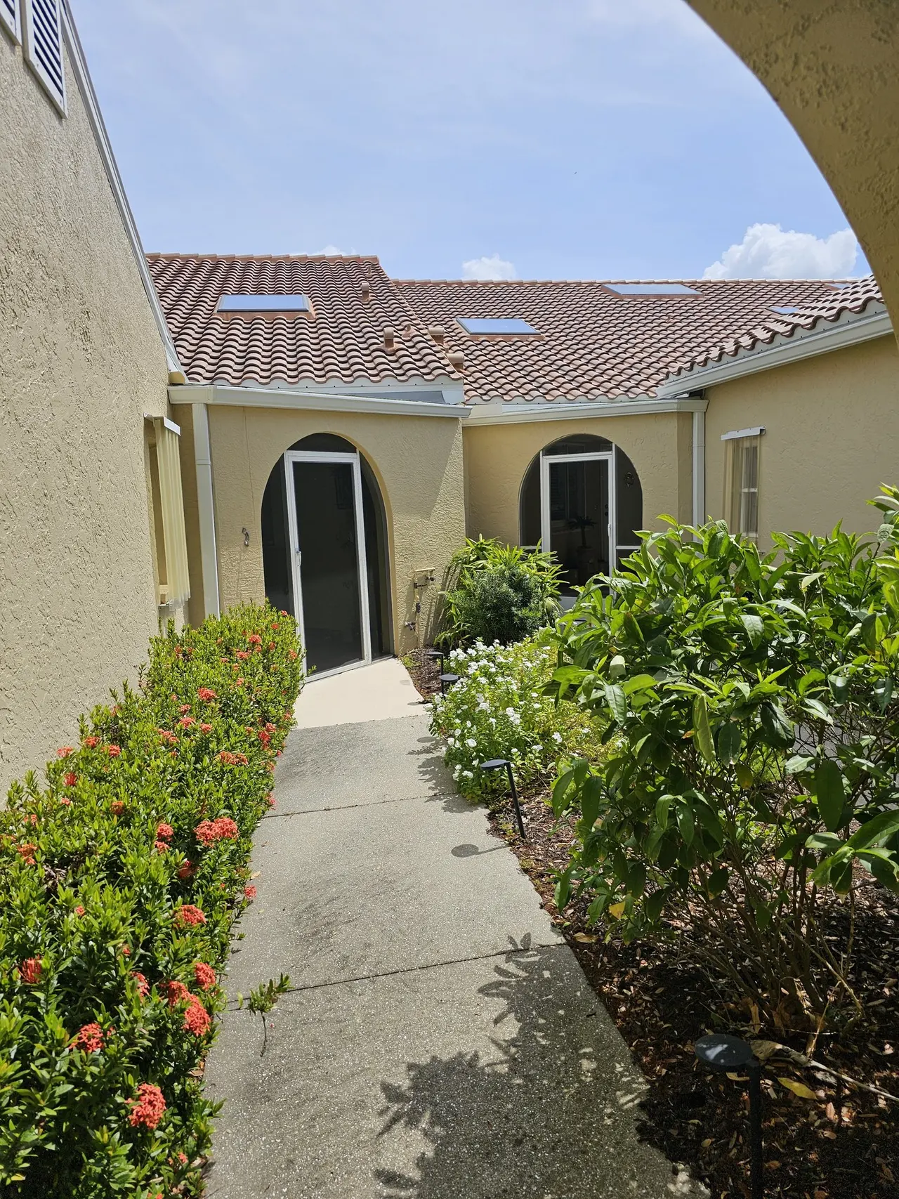 Arched walkway between tile-roof villas with new gutters