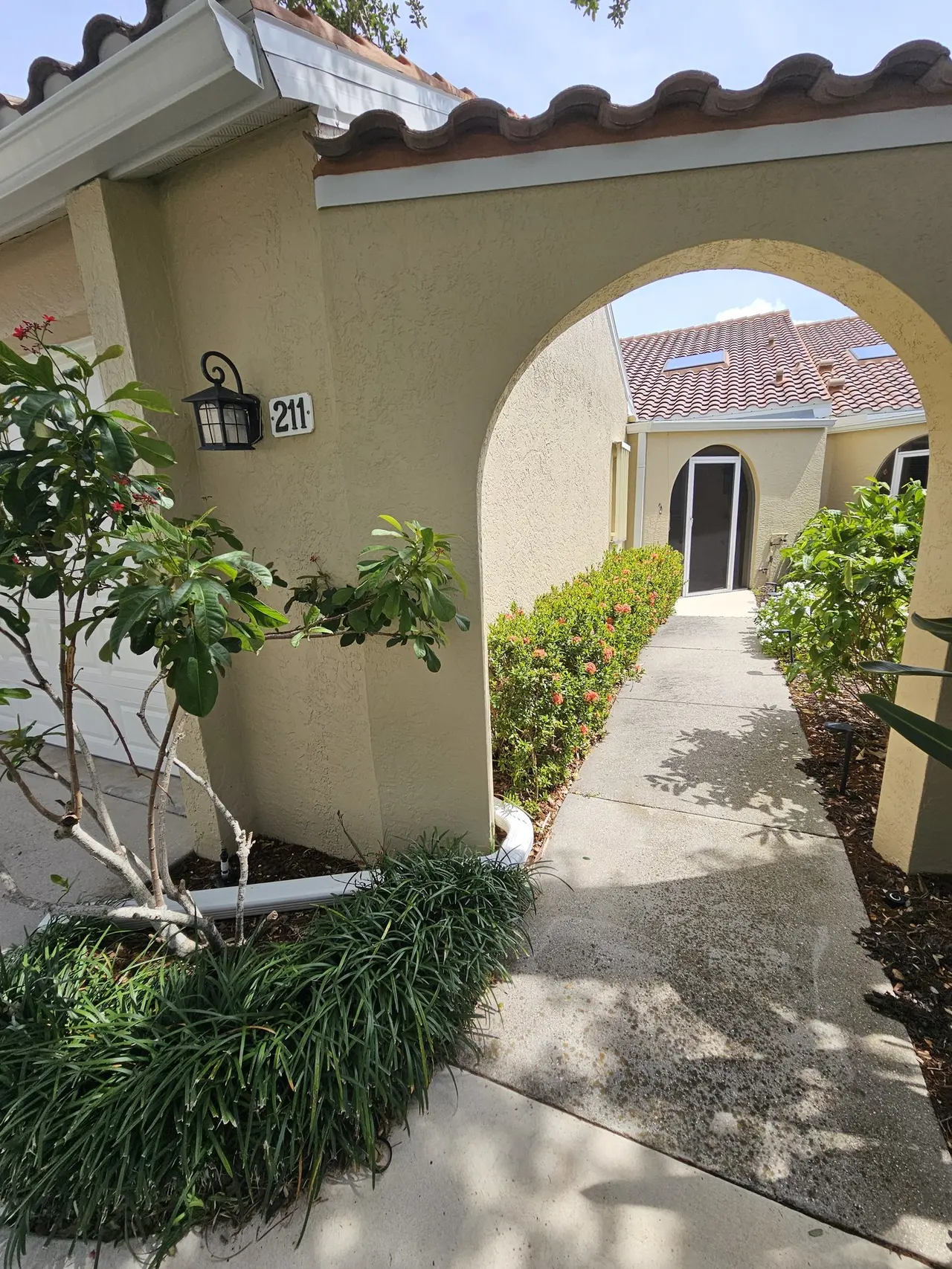 Arched entry of a tile-roof villa with new gutters