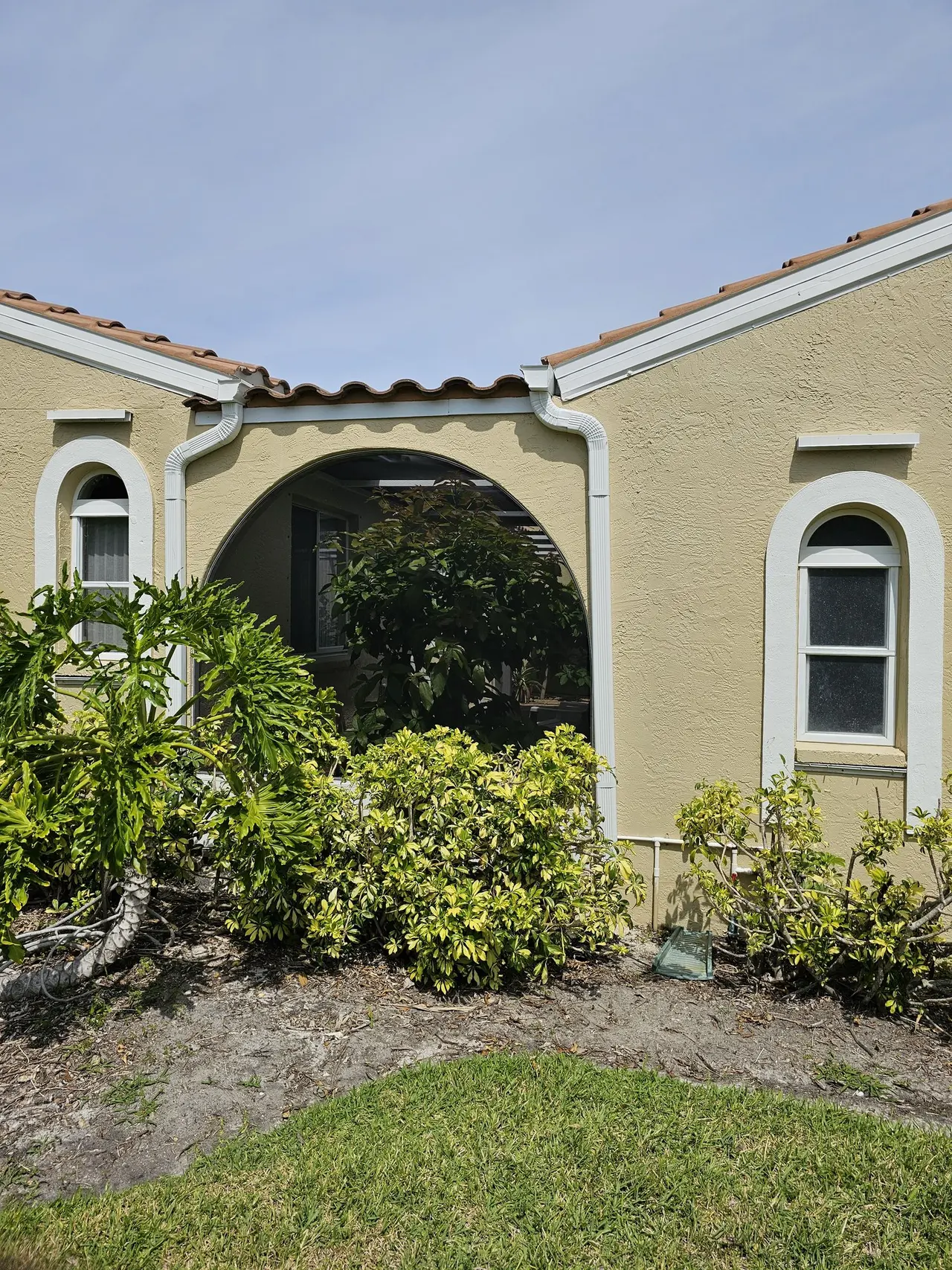 Arched courtyard entry with tile roof and new gutters