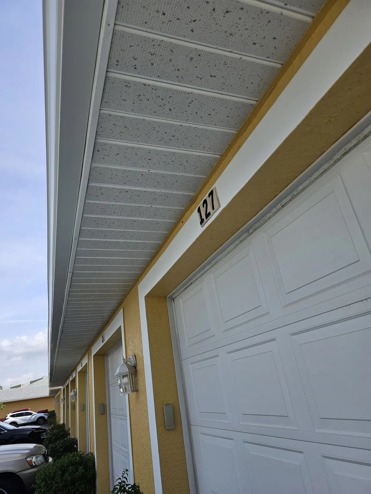 Looking up along a white gutter above the garage doors