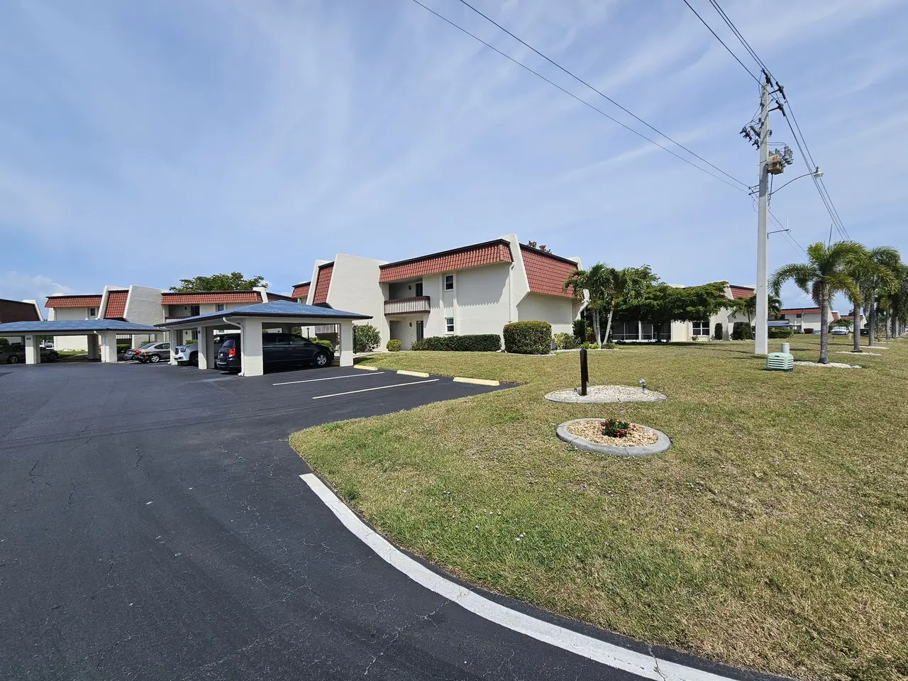 Wide view of the community with carports and tile-roof buildings
