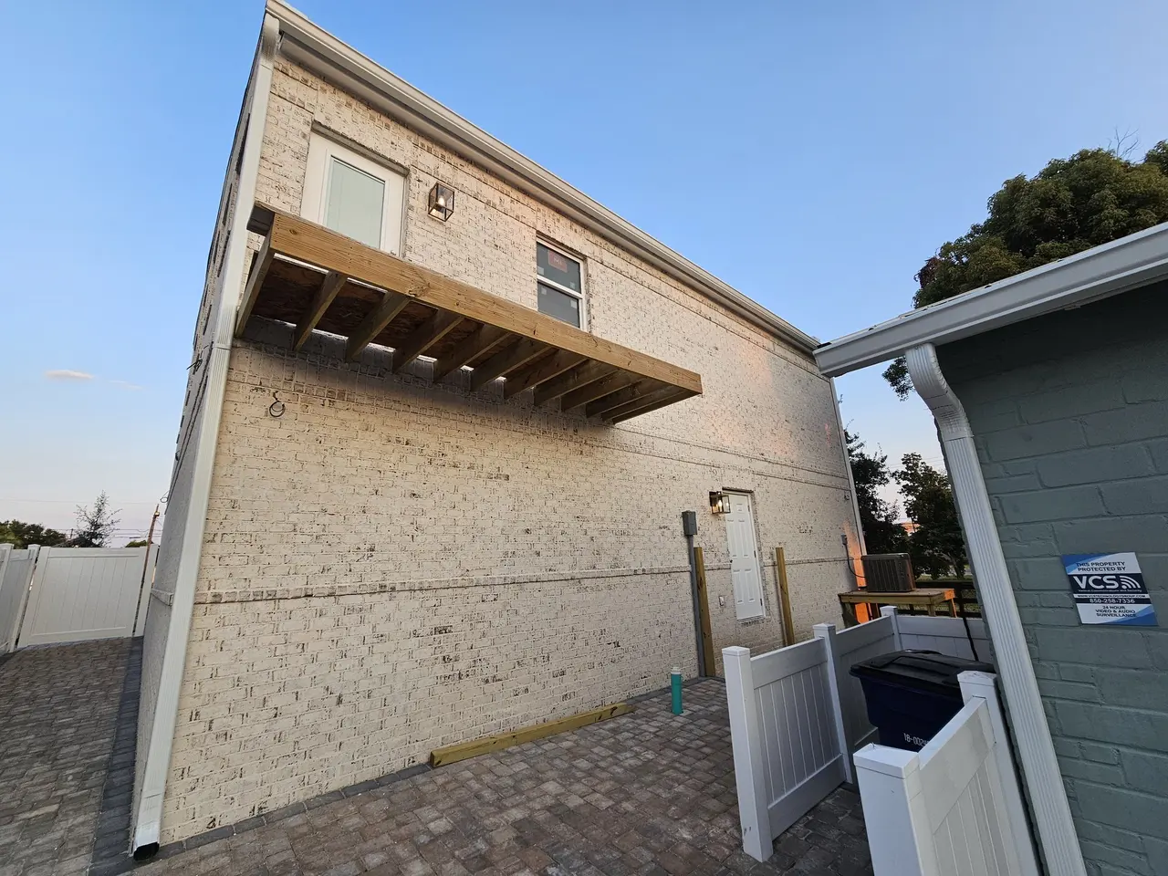 New block home with white seamless gutters at sunset