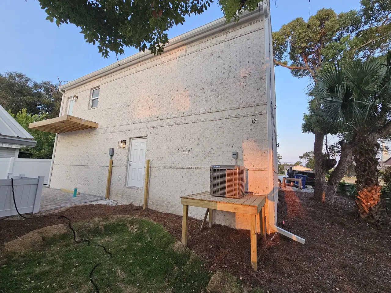 Rear of a new home with white gutters and a deck under construction