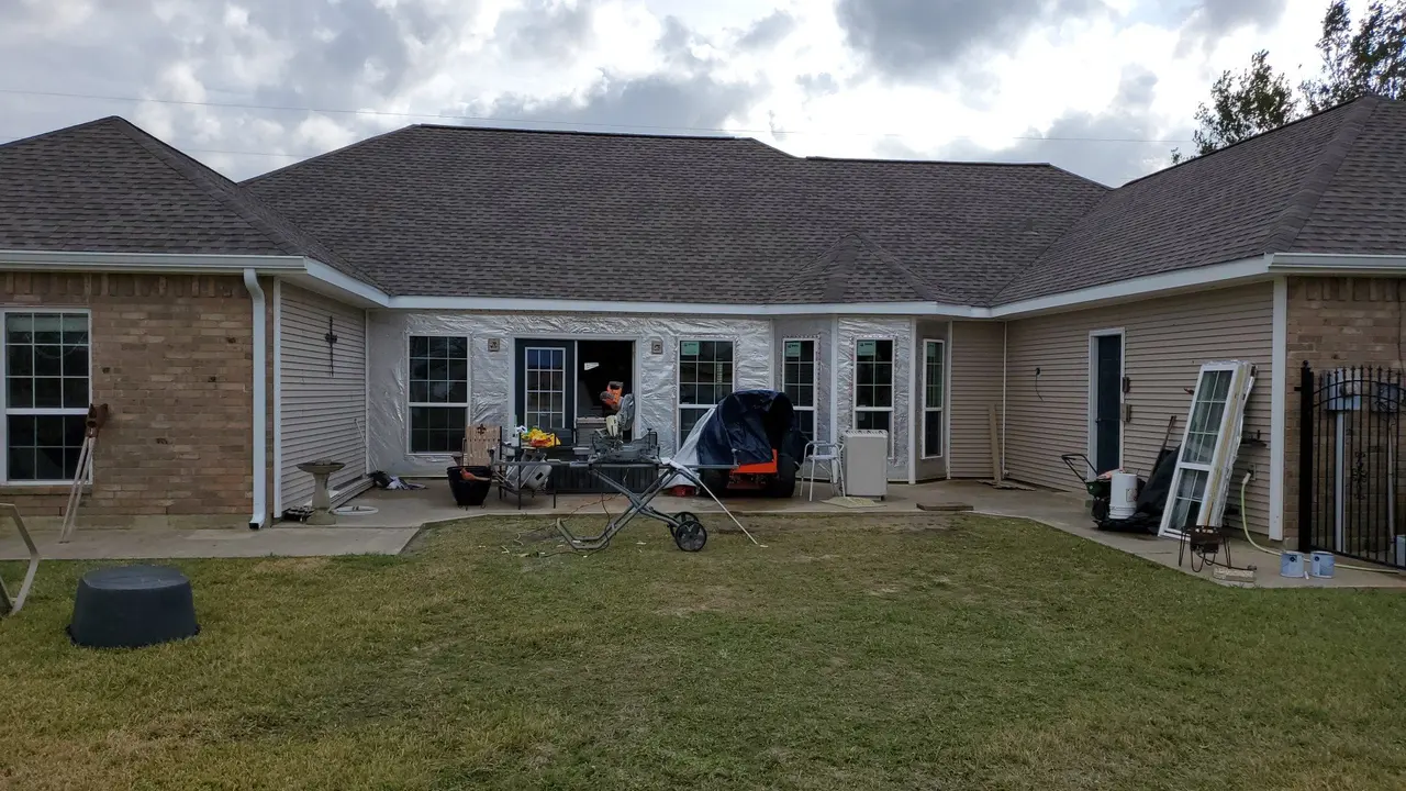 Rear of a brick and siding ranch home with new white gutters along the roofline